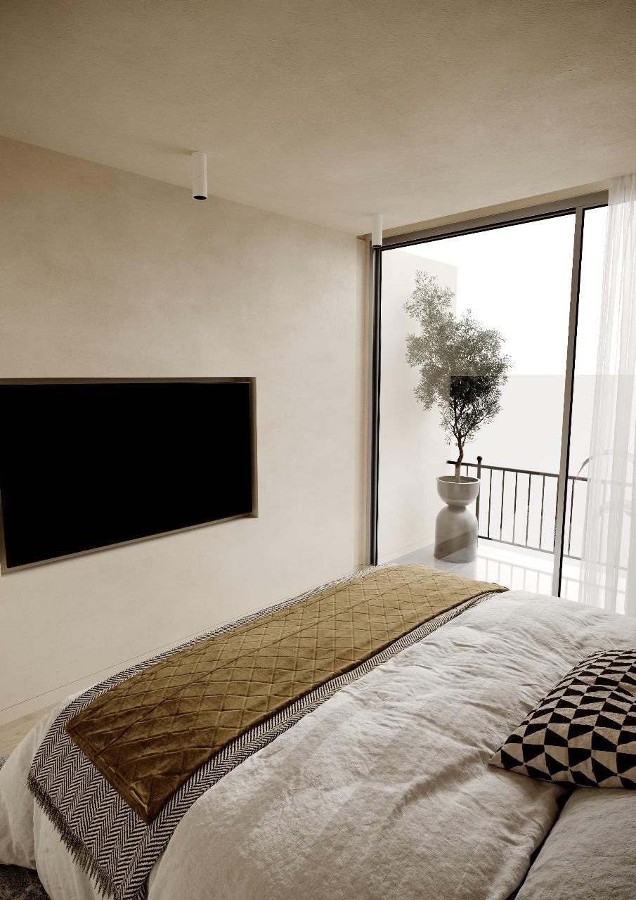 Quarto do T2, com vão de vidro sobre a varanda e oliveira em vaso